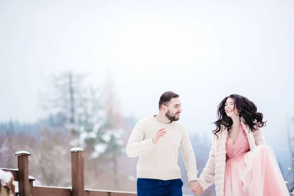 Young couple on a walk in the snowy mountains — Stock Photo, Image