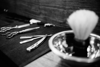 Aynanın önündeki masaüstünde bir berberin araçları