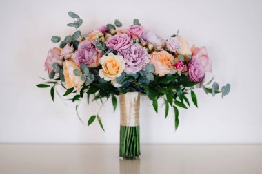 Taze doğal çiçekler ve yeşillik dolu zarif bir düğün buketi.