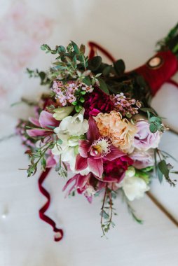 Taze doğal çiçekler ve yeşillik dolu zarif bir düğün buketi.