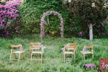 Ormanda yeşil çimlerin üzerindeki ağaçların arasında bir düğün töreni.