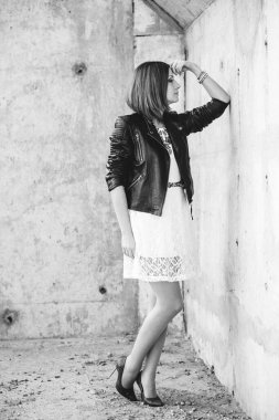 Siyah ceketli, mavi gözlüklü, gri yollu, kızıl saçlı kız.