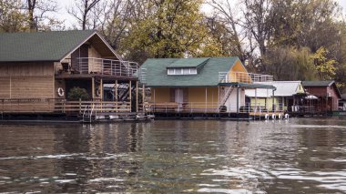 Nehir kıyısına demirlemiş bir sıra salcı evi.