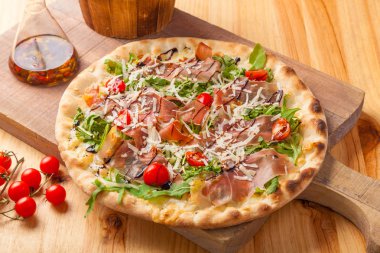 Kurutulmuş jambon pizza, roket bırakır, domates ve Parmesan peyniri 