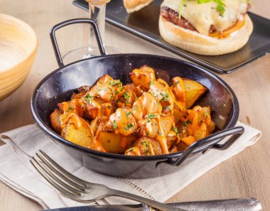 Patatas bravas, spicy potatoes, a typical Spanish dish with frie clipart