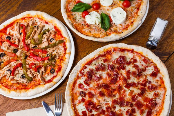 Bir ahşap restoran tabloda birkaç farklı pizza.