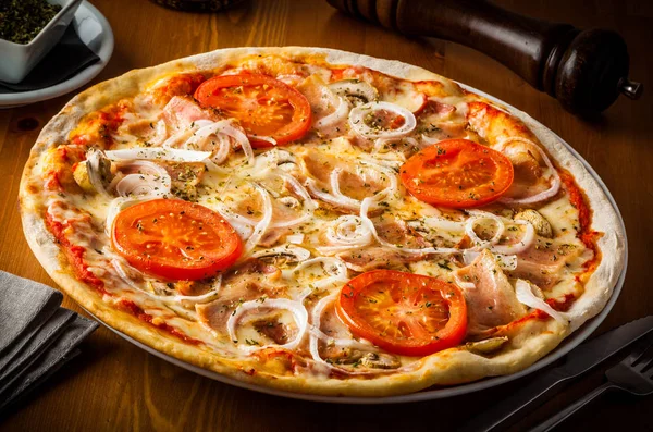 Pizza com tomate, queijo, bacon, cebola e tomate . — Fotografia de Stock