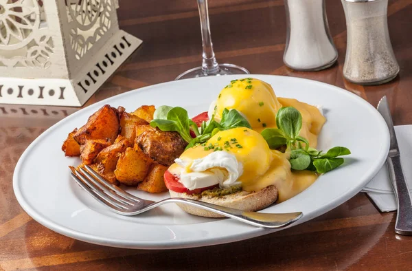 Ovos Benedict servido com batatas para brunch — Fotografia de Stock