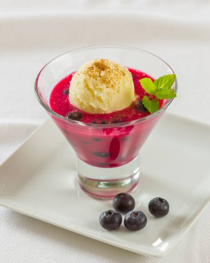 Yaban mersini suyu vanilyalı dondurma bir kepçe ile tepesinde bir tatlı