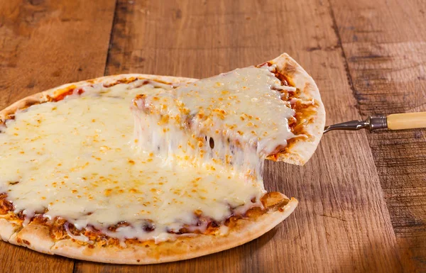 Uma fatia de pizza quente apenas do forno com queijo derretido pingando . — Fotografia de Stock