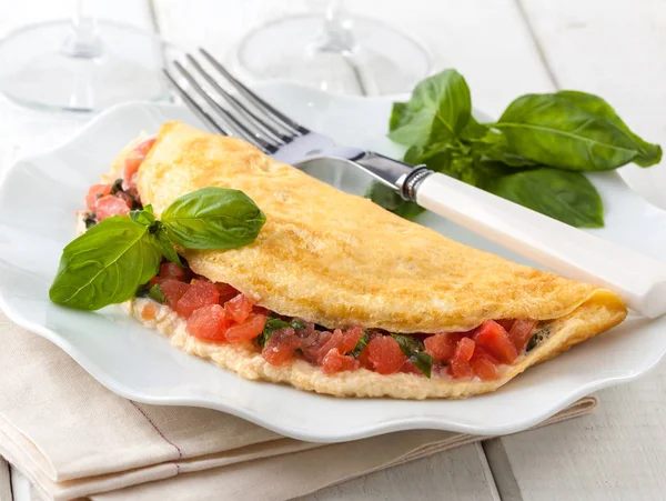 Delicioso omelete estilo italiano cheio de tomate e manjericão . — Fotografia de Stock