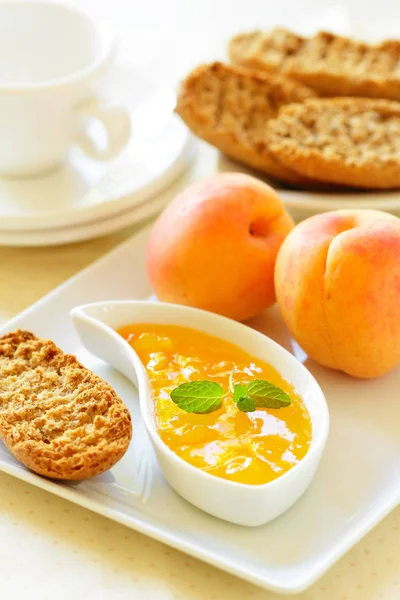 Abrikozenjam, rijpe abrikozen, toast en een koffiekopje. — Stockfoto