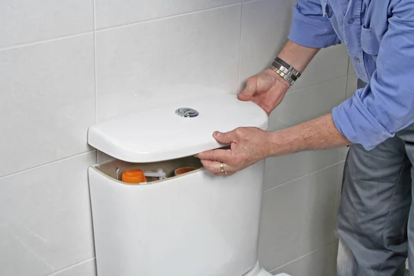 Plumber repairing a toilet cistern — Stock Photo, Image