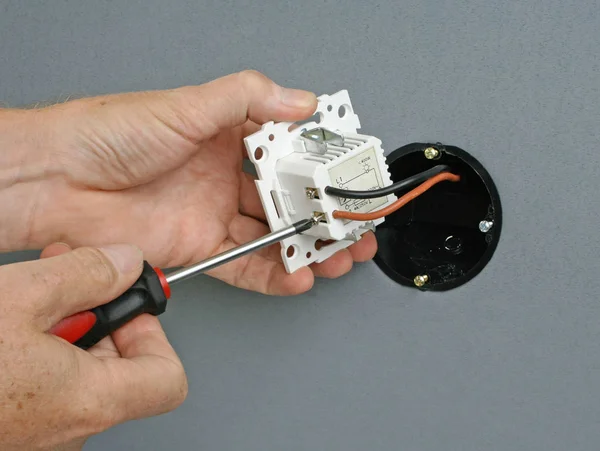 Duvardaki bir prize dimmer anahtarı yükleme elektrikçi — Stok fotoğraf