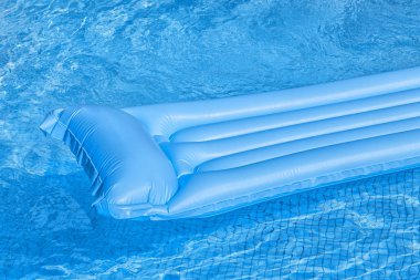 Mavi bir yüzme havuzunda yüzen şişme.