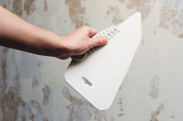 Duvar kağıdı için spatula tutan el