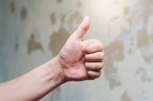 Başparmak yukarıya üstünde düzensiz duvar bir arka plan
