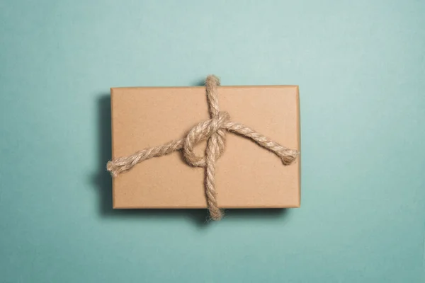 Rustik hediye kutusu masada yeşil boyalı. Paketli hediye kutusu kahverengi kağıt ve sicim geri dönüştürülmüş. Kavramlardır tatil hediye, Eko Dostu ambalaj, rustik tarzı hediye sarma.