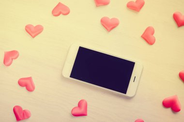 Üstten Görünüm ahşap Resepsiyon arka plan üzerinde akıllı telefon ve sevgi kalpleri üzerinde. Düz yatıyordu stil alanı portre resmi Kopyala