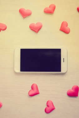 Üstten Görünüm ahşap Resepsiyon arka plan üzerinde akıllı telefon ve sevgi kalpleri üzerinde. Düz yatıyordu stil alanı portre resmi Kopyala