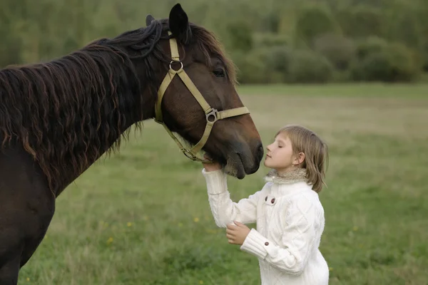 Jong meisje model weggerukt zijn gezicht naar het paard. Portret van de levensstijl — Stockfoto