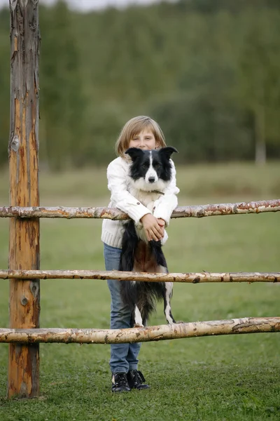 Retrato de una niña pequeña con la raza de perros frontera collie. Al aire libre. Estilo de vida — Foto de Stock