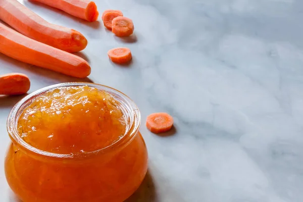 Close up home made orange carrot marmalade jam kitchen marble table with copy space. — Stock Photo, Image