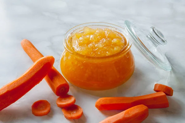 Ev yapımı havuç marmelatı reçel kavanozu ve kapak mutfak mermer masa arka planı..