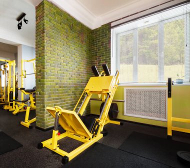 Yeni açık modern spor salonunun içi yeşil renkli ve sarı ekipmanlı.