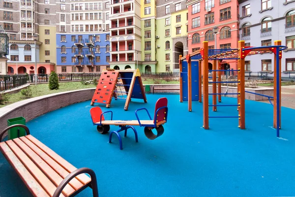 Niños parque infantil y edificio de la casa exterior de uso mixto urbano multi-familia residencial distrito desarrollo azul fondo copia espacio — Foto de Stock