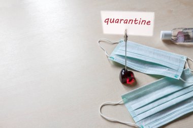 Kalp standında uyarı işareti - tıbbi yüz maskesi karantinası ve antiseptik el jeli hastane masası arka planında fotokopi alanı var. NCoV alarmı. Evde kal.