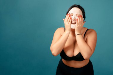 Mutlu artı beden kız tam bölüşüyor. Mutlu vücut pozitifliği. Vücudumu seviyorum. Beyaz nemlendirici maskeli çekici şişman kadın.