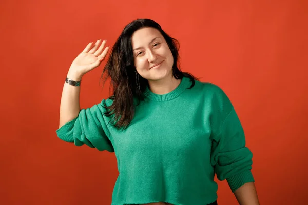 Happy plus size positive woman. Happy body positive concept. I love my body. Attractive overweight woman posing on camera in the studio on a colored background. Girl wearing a sweater