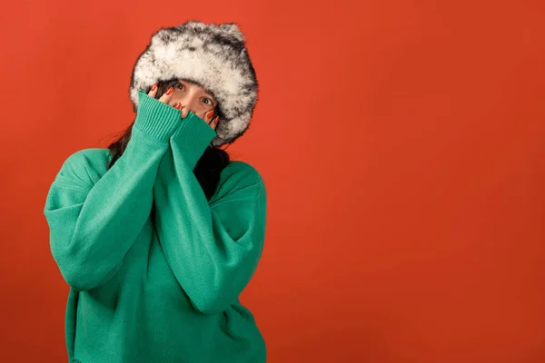 Happy plus size positive woman. Happy body positive concept. I love my body. Attractive overweight woman posing on camera in the studio on a colored background. Girl wearing a sweater and a winter hat