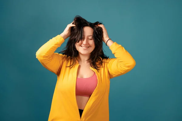 Happy plus size positive woman. Happy body positive concept. I love my body. Attractive overweight woman dressed in a yellow suit fun posing for the camera and scratching her head