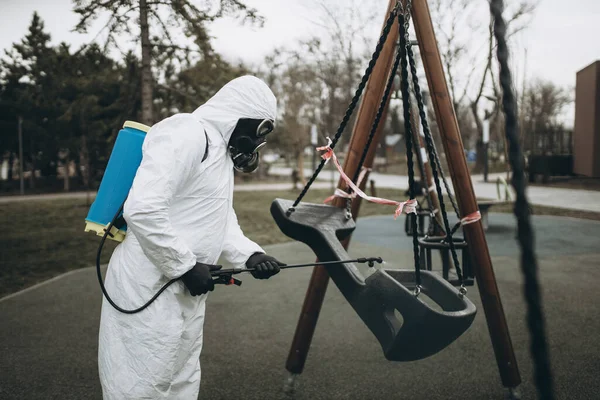 Cleaning and Disinfection on the playground in the sity complex amid the coronavirus epidemic Professional teams for disinfection efforts Infection prevention and control of epidemic Protective suit and mask and spray bag,