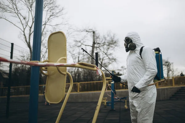 Cleaning and Disinfection on the playground in the sity complex amid the coronavirus epidemic Professional teams for disinfection efforts Infection prevention and control of epidemic Protective suit and mask and spray bag,