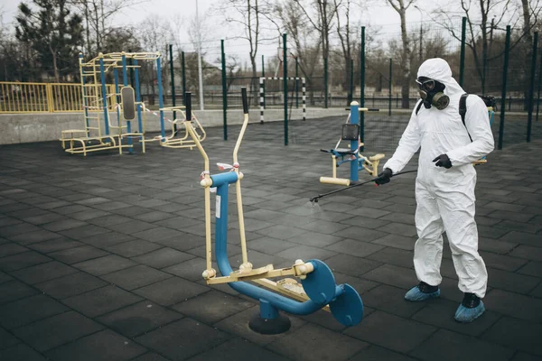 Cleaning and Disinfection on the playground in the sity complex amid the coronavirus epidemic Professional teams for disinfection efforts Infection prevention and control of epidemic Protective suit and mask and spray bag,