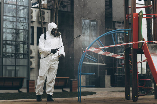 Cleaning and Disinfection on the playground in the sity complex amid the coronavirus epidemic Professional teams for disinfection efforts Infection prevention and control of epidemic Protective suit and mask and spray bag,