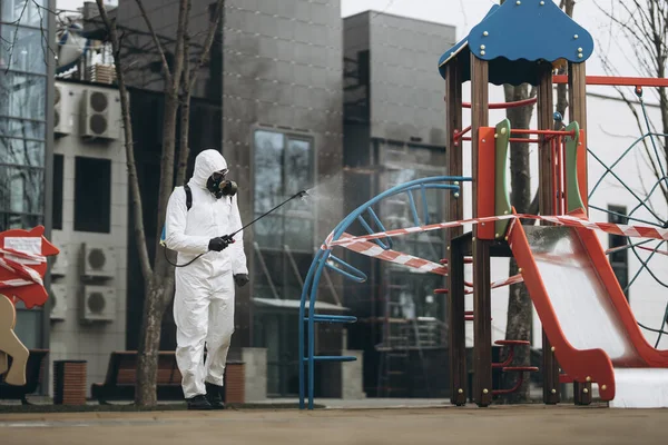 Cleaning and Disinfection on the playground in the sity complex amid the coronavirus epidemic Professional teams for disinfection efforts Infection prevention and control of epidemic Protective suit and mask and spray bag,