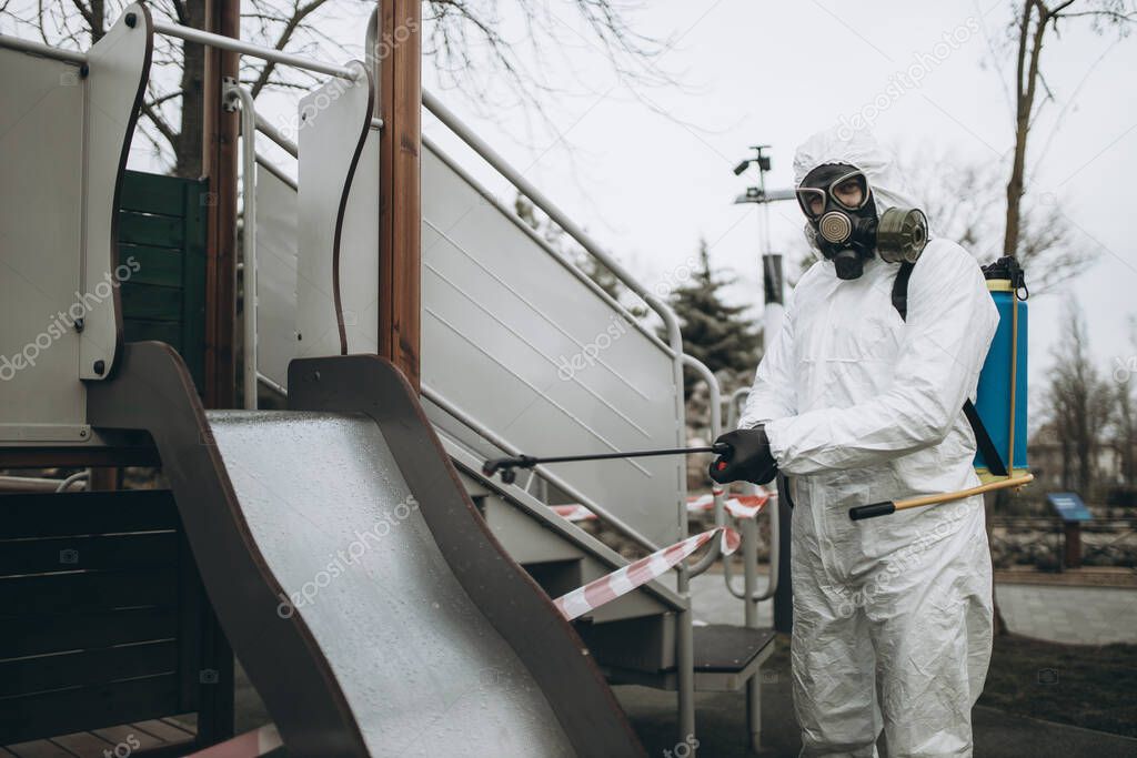 Cleaning and Disinfection on the playground in the sity complex amid the coronavirus epidemic Professional teams for disinfection efforts Infection prevention and control of epidemic Protective suit and mask and spray bag,