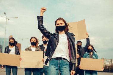 Koronavirüs karşıtı protestoları ve koronavirüs ve insan haklarıyla ilgili karantina toplantısını protesto etmek için posterlerle gelen maskeli bir grup insan. Kopyalama alanı