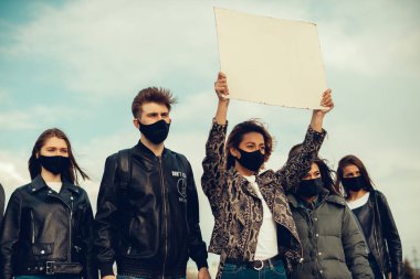 Koronavirüs karşıtı protestoları ve koronavirüs ve insan haklarıyla ilgili karantina toplantısını protesto etmek için posterlerle gelen maskeli bir grup insan. Kopyalama alanı