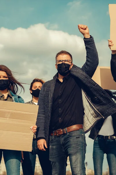 A group of people with mask who came out with posters to protest The protest of the population against coronavirus and against the introduction of quarantine Meeting about coronavirus and people rights. Copyspace