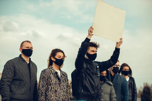 A group of people with mask who came out with posters to protest The protest of the population against coronavirus and against the introduction of quarantine Meeting about coronavirus and people rights. Copyspace