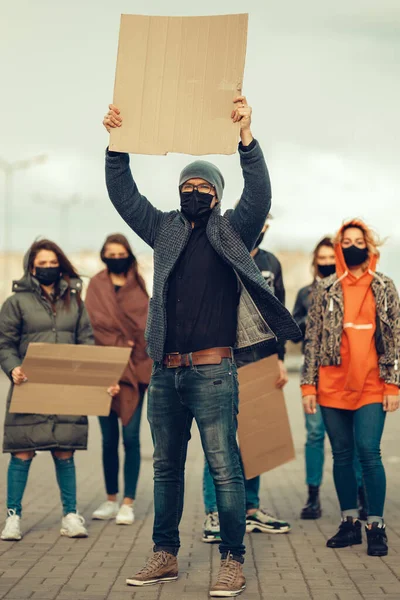 A group of people with mask who came out with posters to protest The protest of the population against coronavirus and against the introduction of quarantine Meeting about coronavirus and people rights. Copyspace