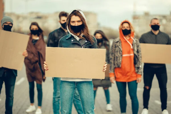 A group of people with mask who came out with posters to protest The protest of the population against coronavirus and against the introduction of quarantine Meeting about coronavirus and people rights. Copyspace