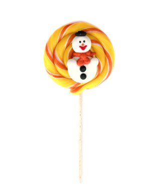 Beyaz arka planda izole edilmiş bir çubukta şeker. Sarı lolipop ve kardan adam. Noel için büyük karamel.