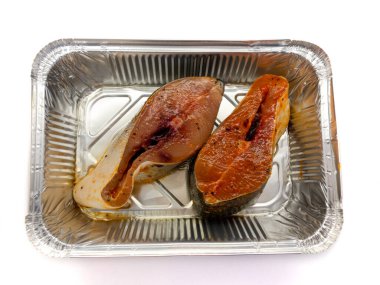 Beyaz arka planda izole edilmiş folyodaki somon balığı. Çiğ somon bifteği. Kızarmış balık..