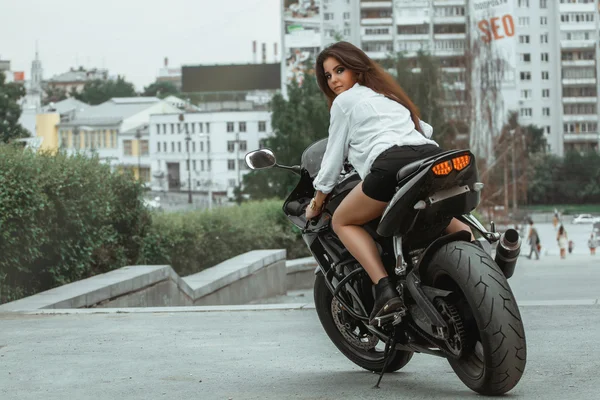 Biker girl rides a motorcycle in the rain. First-person view